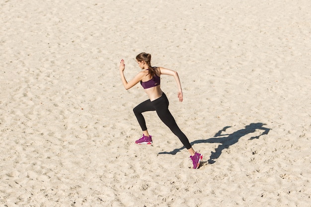 Jonge vrouw die buiten traint in de herfstzonneschijn concept van een gezonde levensstijl van sport