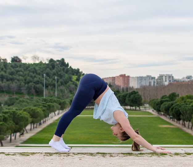 Jonge vrouw die buiten yoga beoefent en de positieve energie door haar lichaam voelt stromen