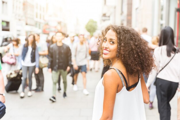 Jonge vrouw die camera bekijkt terwijl het lopen in Londen