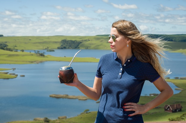 Foto jonge vrouw die chimarro-partner met prachtig uitzicht drinkt