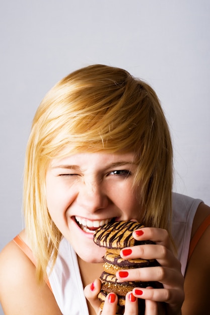 Jonge vrouw die chocoladeschilferkoekjes eet