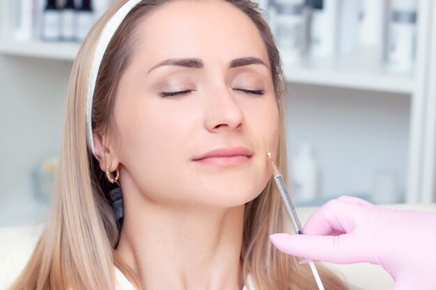 Jonge vrouw die cosmetische injectie van botox ontvangt, close-up. Vrouw in een schoonheidssalon. Kliniek voor plastische chirurgie.