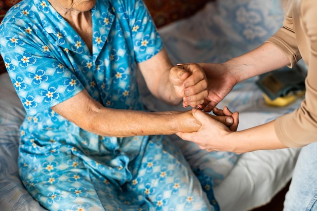 Jonge vrouw die de hand van een oudere vrouw vasthoudt