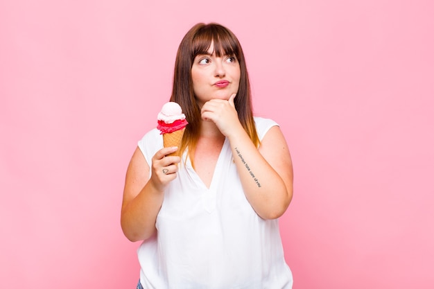 Jonge vrouw die denkt, zich twijfelachtig en verward voelt, met verschillende opties, zich afvraagt welke beslissing ze moet nemen