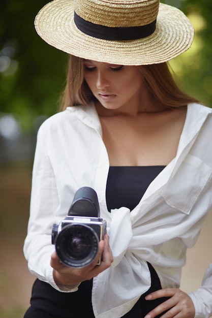 Jonge vrouw die door cameralens kijkt