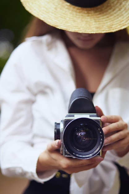 Jonge vrouw die door cameralens kijkt