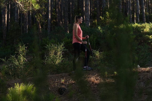 Jonge vrouw die door het bos loopt bij zonsondergang