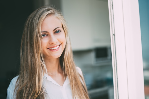 Jonge vrouw die door het venster kijkt