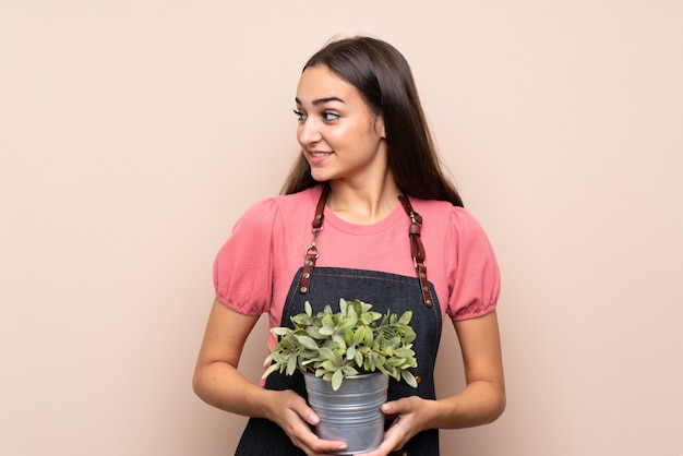 Jonge vrouw die een bloempot neemt