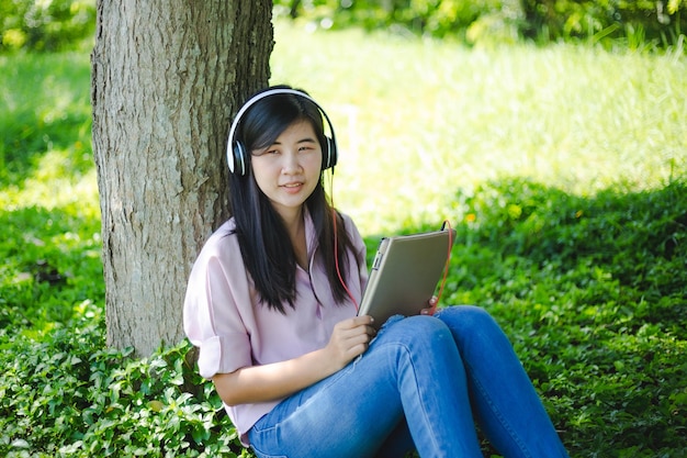 Jonge vrouw die een boek leest in de zomernatuur Een vrouw die een boek buitenshuis leest