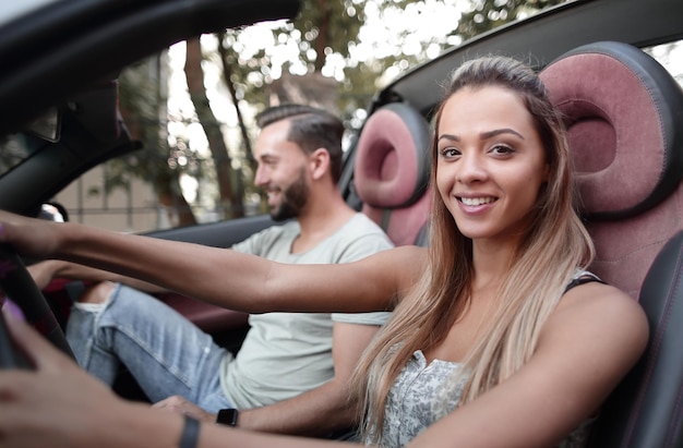 Jonge vrouw die een cabriolet bestuurt