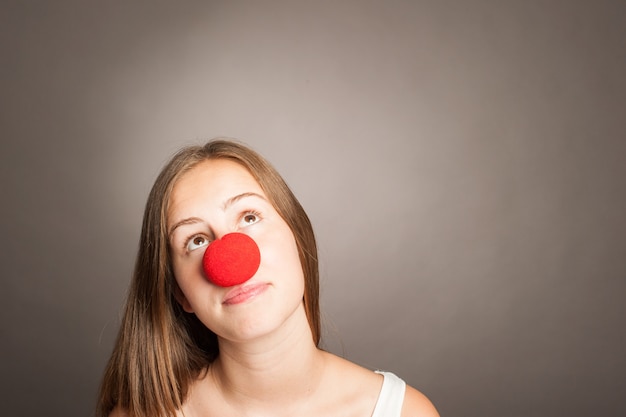 Jonge vrouw die een clownneus met exemplaarruimte draagt