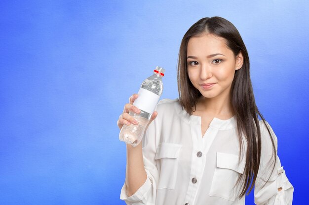 Jonge vrouw die een fles water toont