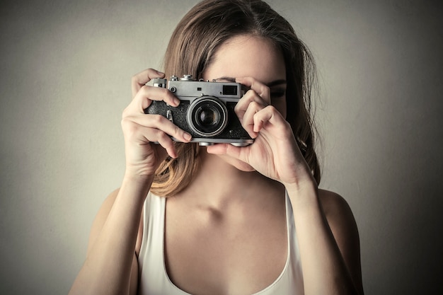 Jonge vrouw die een foto met een camera neemt