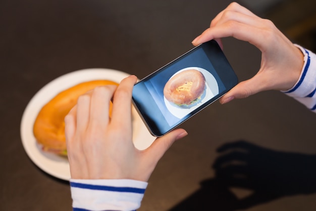 Jonge vrouw die een foto van haar lunch neemt