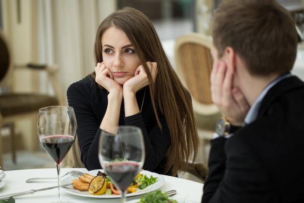 Jonge vrouw die een geërgerd uitdrukkingsgebaar op een slechte datum maken bij het restaurant