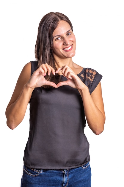 Jonge vrouw die een hart met haar handen op witte achtergrond maakt