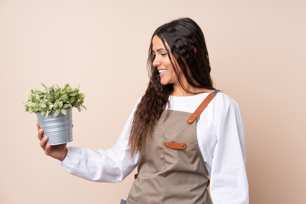 Jonge vrouw die een installatie met gelukkige uitdrukking houdt