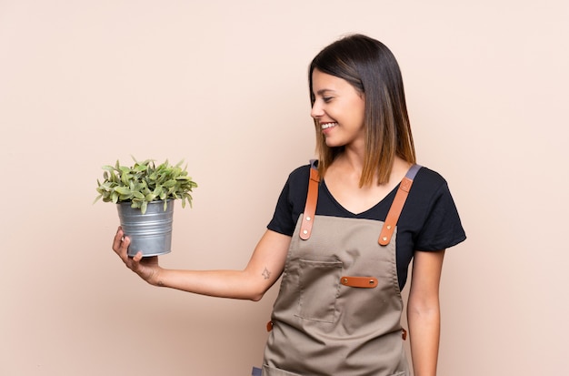 Jonge vrouw die een installatie met gelukkige uitdrukking houdt