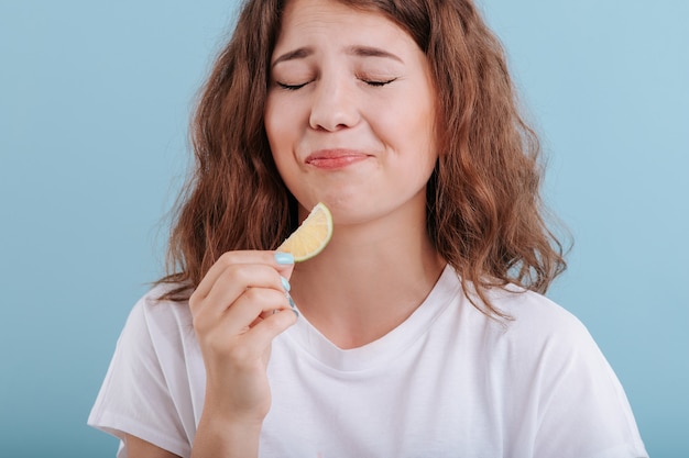 Jonge vrouw die een kalkplak eet