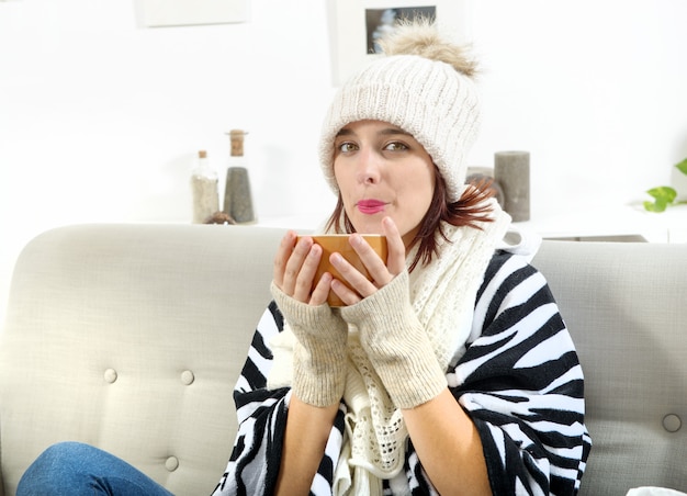 Jonge vrouw die een kop thee drinkt