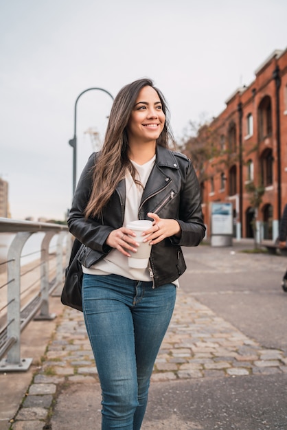 Jonge vrouw die een kop van koffie houdt