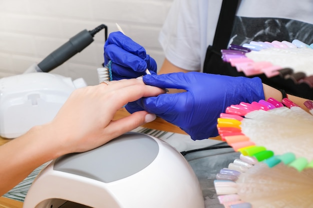 Jonge vrouw die een manicureservice ontvangt in een schoonheidssalon.