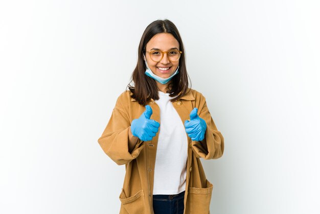 Jonge vrouw die een masker draagt om tegen covid te beschermen met omhoog duimen