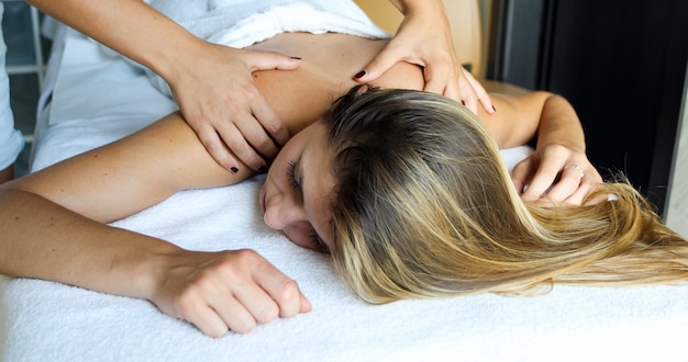 Jonge vrouw die een massage in een kuuroord krijgt