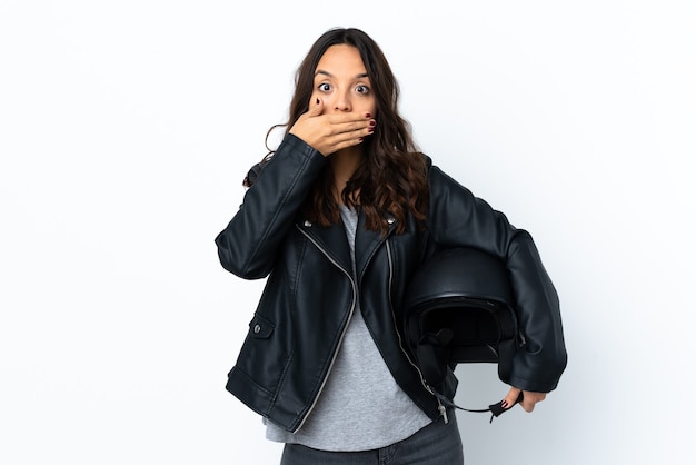 Jonge vrouw die een motorhelm over geïsoleerd wit houdt die mond behandelt met handen