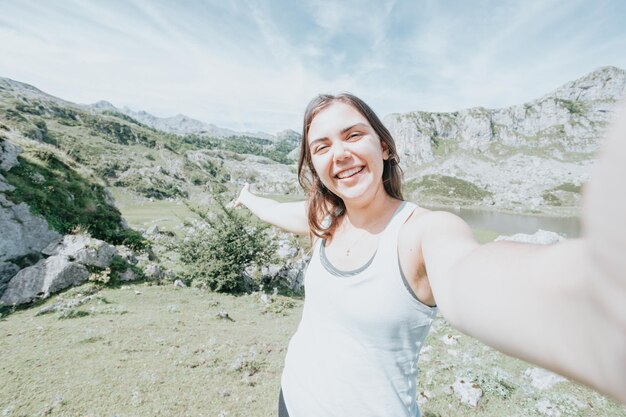 Jonge vrouw die een selfie op de bergen neemt na een reisdag. idyllische scenario's van de spaanse bergen die het leven vieren. rust na een dag wandelen kopieer ruimte voor add