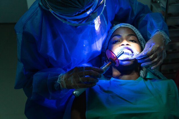 Jonge vrouw die een tandbleekbehandeling krijgt bij de tandarts