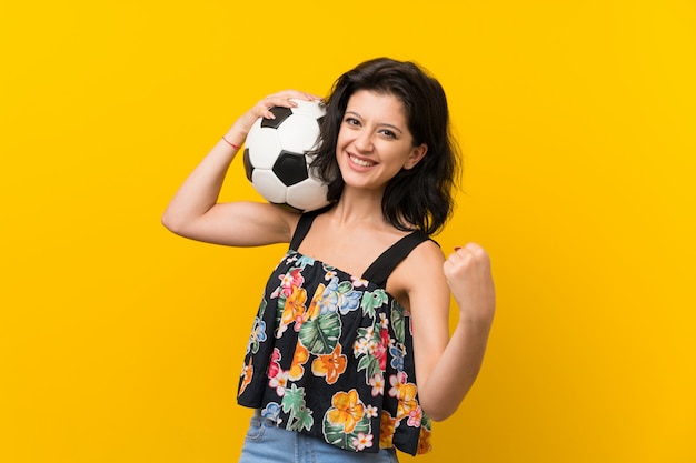 Jonge vrouw die een voetbalbal houdt