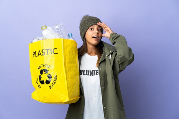 Jonge vrouw die een zak vol plastic houdt die verrassingsgebaar doet terwijl zij naar de zijkant kijkt