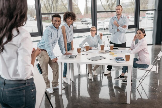 Jonge vrouw die een zakelijk seminar geeft voor haar collega's op kantoor