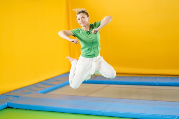 Jonge vrouw die en op een trampoline in sportcentrum springt stuitert