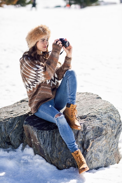 Jonge vrouw die foto's in de sneeuwbergen neemt