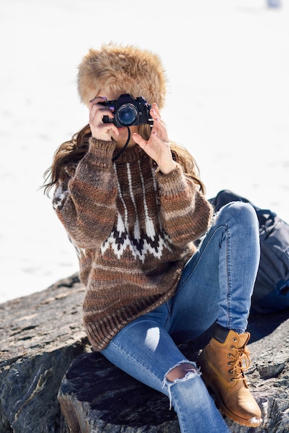 Jonge vrouw die foto's in de sneeuwbergen neemt