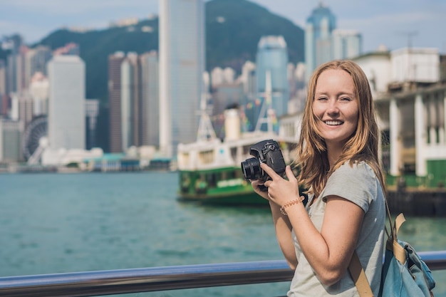 Jonge vrouw die foto's maakt van de haven van Victoria in Hong Kong, China.