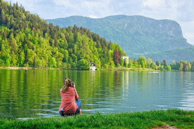 Jonge vrouw die foto's maakt van het meer van Bled, Slovenië