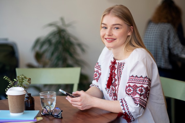 Foto jonge vrouw die geborduurd overhemd draagt