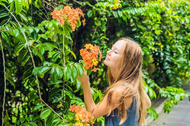 Jonge vrouw die geniet van een prachtige bloeiende tuin