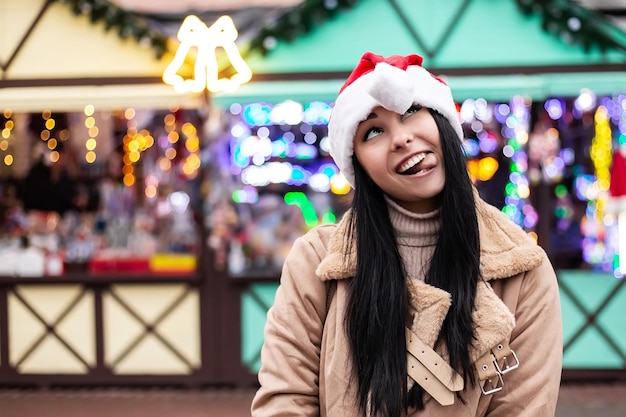 Jonge vrouw die gezichten trekt en lacht op de wintermarkt