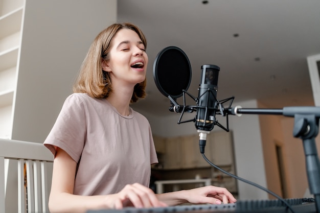 Jonge vrouw die haar eigen lied thuis opneemt