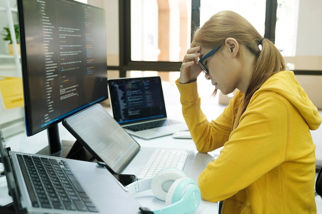 Jonge vrouw die haar gezicht bedekt met de stress van het coderen en programmeren van software