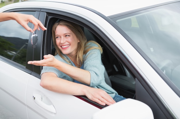 Jonge vrouw die haar nieuwe autosleutel krijgt