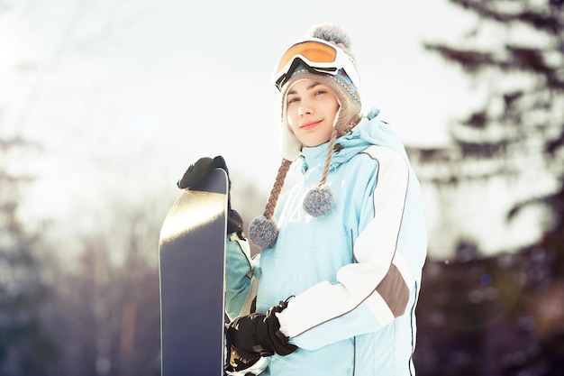 Jonge vrouw die haar snowboard vasthoudt