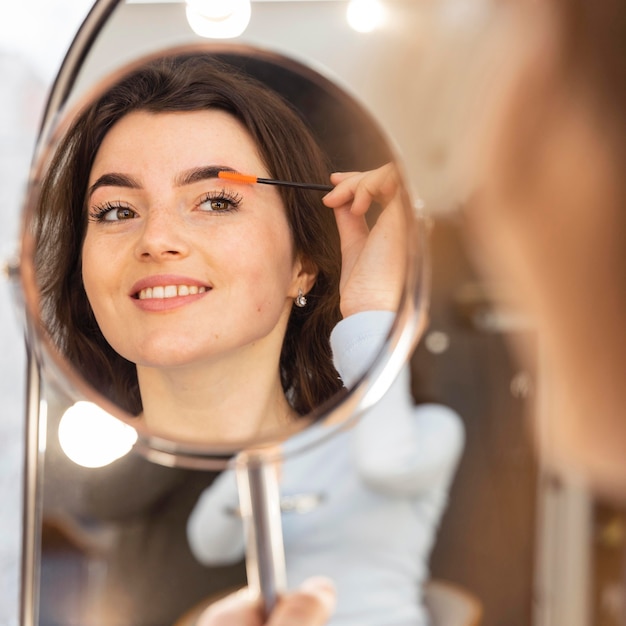 Foto jonge vrouw die haar wenkbrauwen schikt