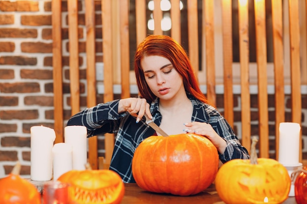 Jonge vrouw die Halloween-pompoen Jackolantern maakt Vrouwelijke handen die pompoenen met mes snijden