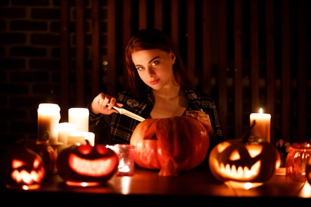 Jonge vrouw die Halloween-pompoen Jackolantern maakt Vrouwelijke handen die pompoenen met mes snijden